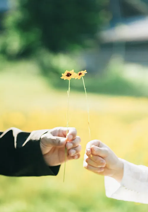 花を持った二人の手の写真