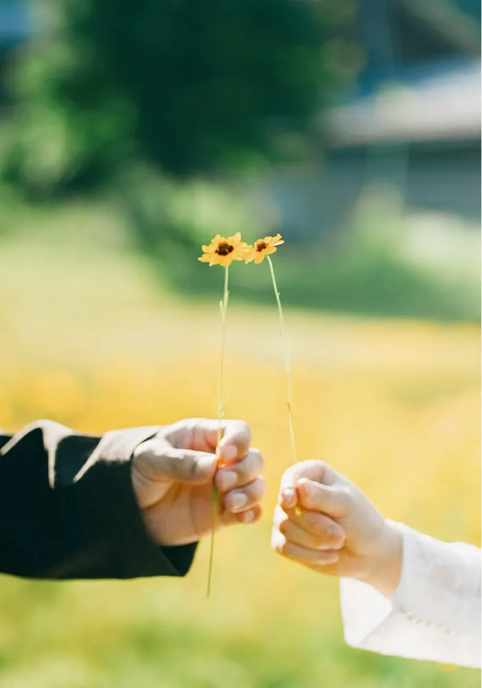 花を持った二人の手の写真